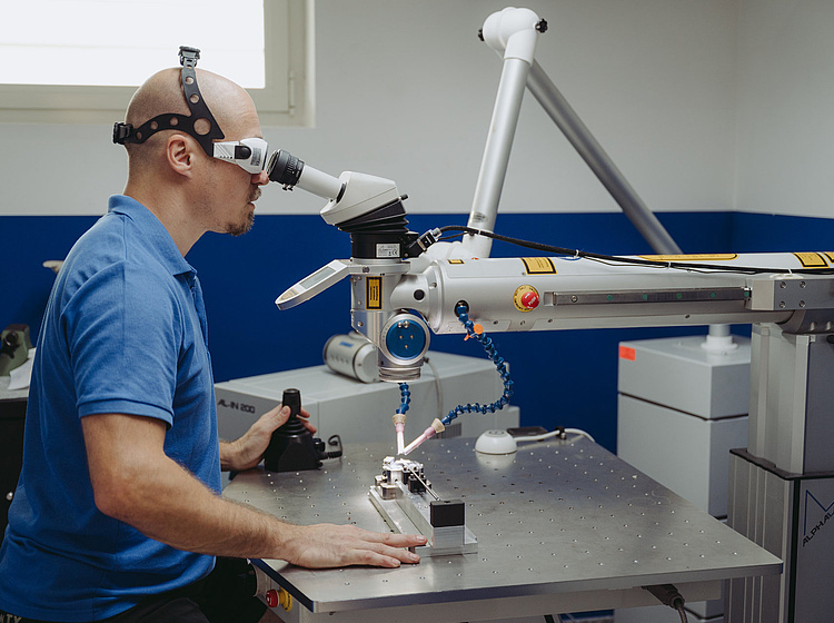 Ein Mitarbeiter von Simply 3D an einem Laserschweißgerät Mitarbeiter von Simply 3D schweißt etwas an einem Laserschweißgerät